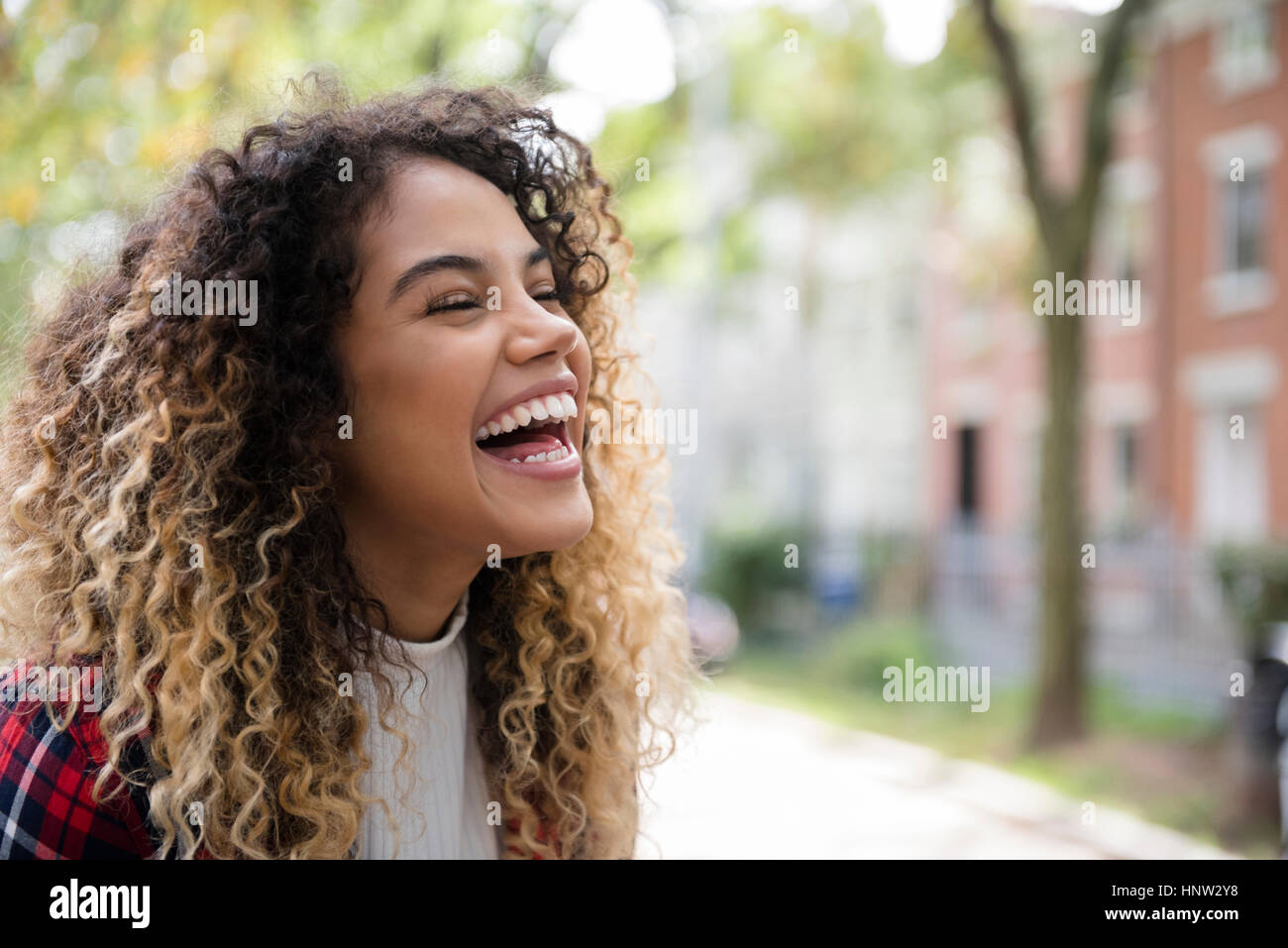 Mixed Race woman laughing in city Stock Photo
