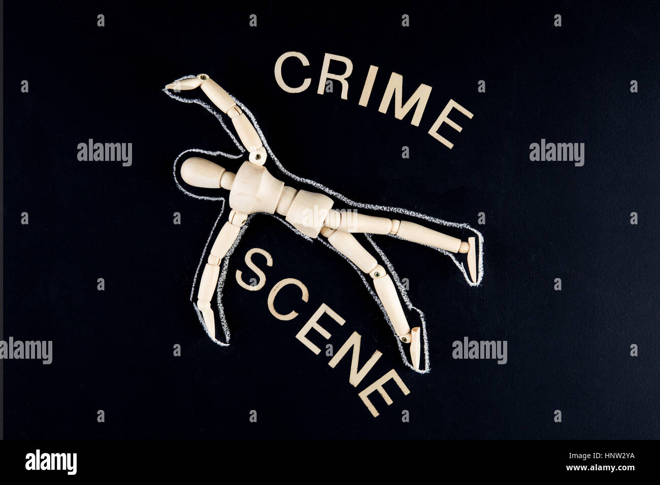 wooden dummy figurine laying on the floor with chalk outline - crime investigation concept Stock Photo