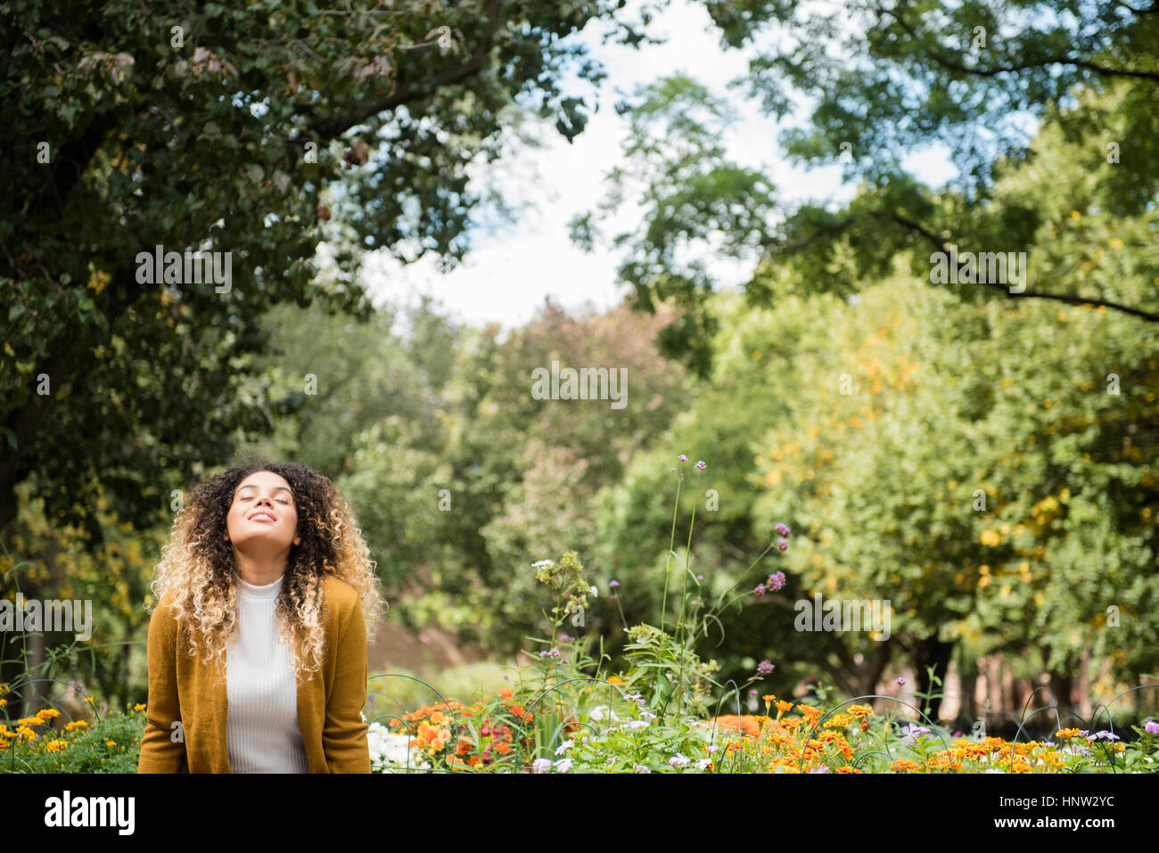 Mixed Race woman relaxing in park Stock Photo