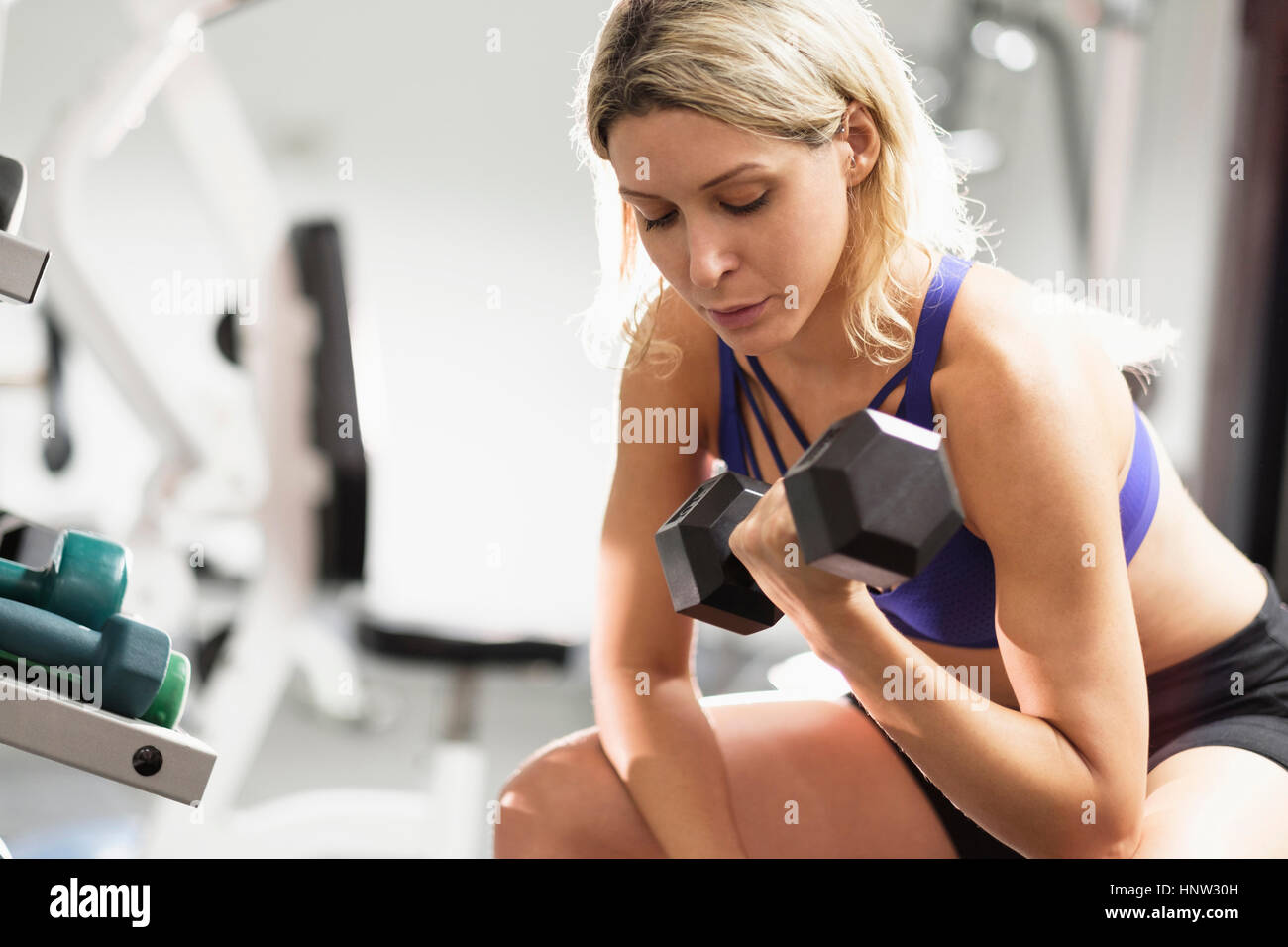 Mixed Race woman doing curls with dumbbell Stock Photo