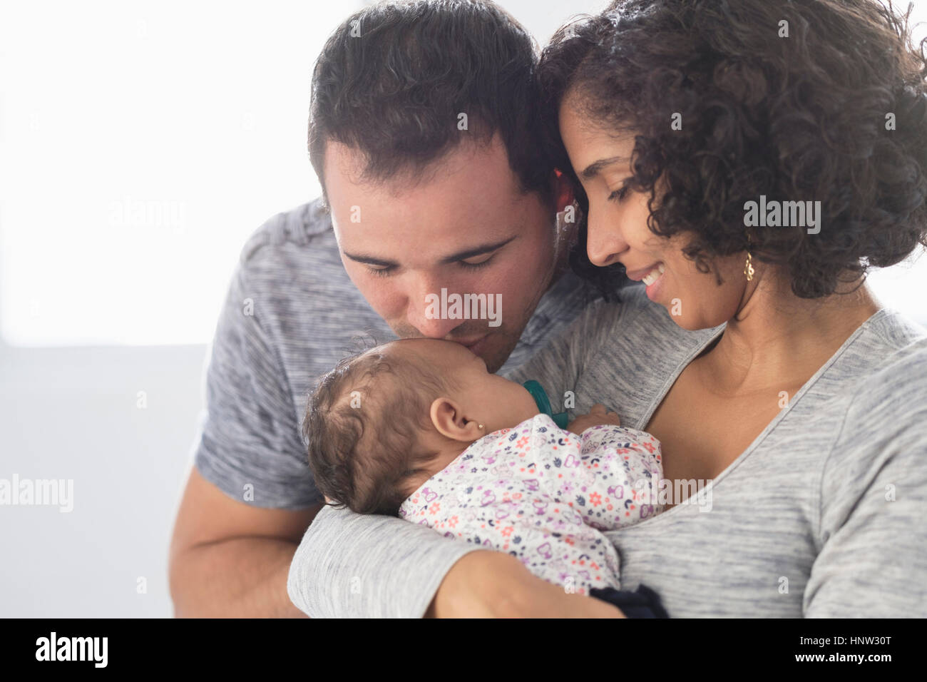 Hispanic father kissing baby daughter Stock Photo