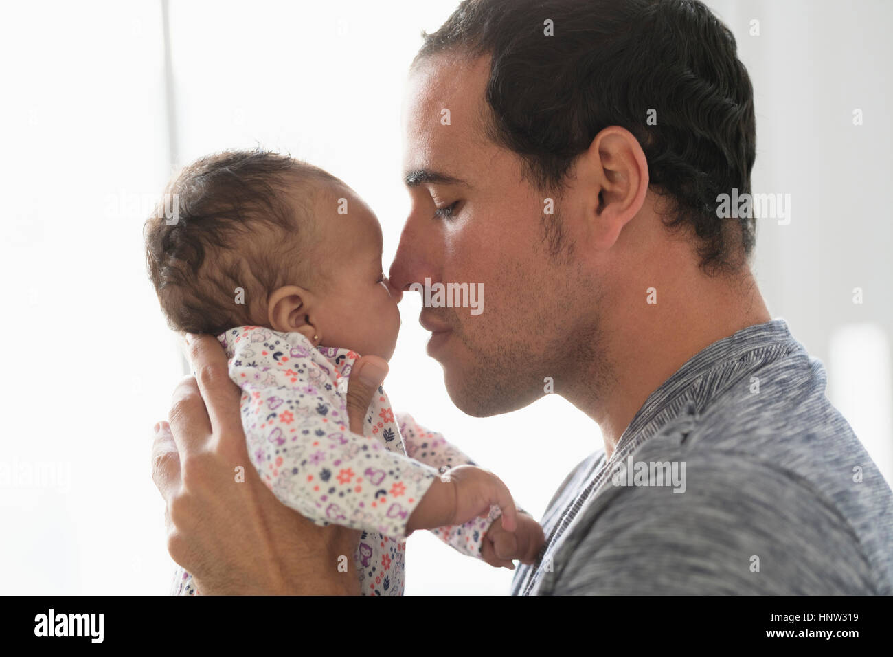 Hispanic father rubbing noses with baby daughter Stock Photo Alamy