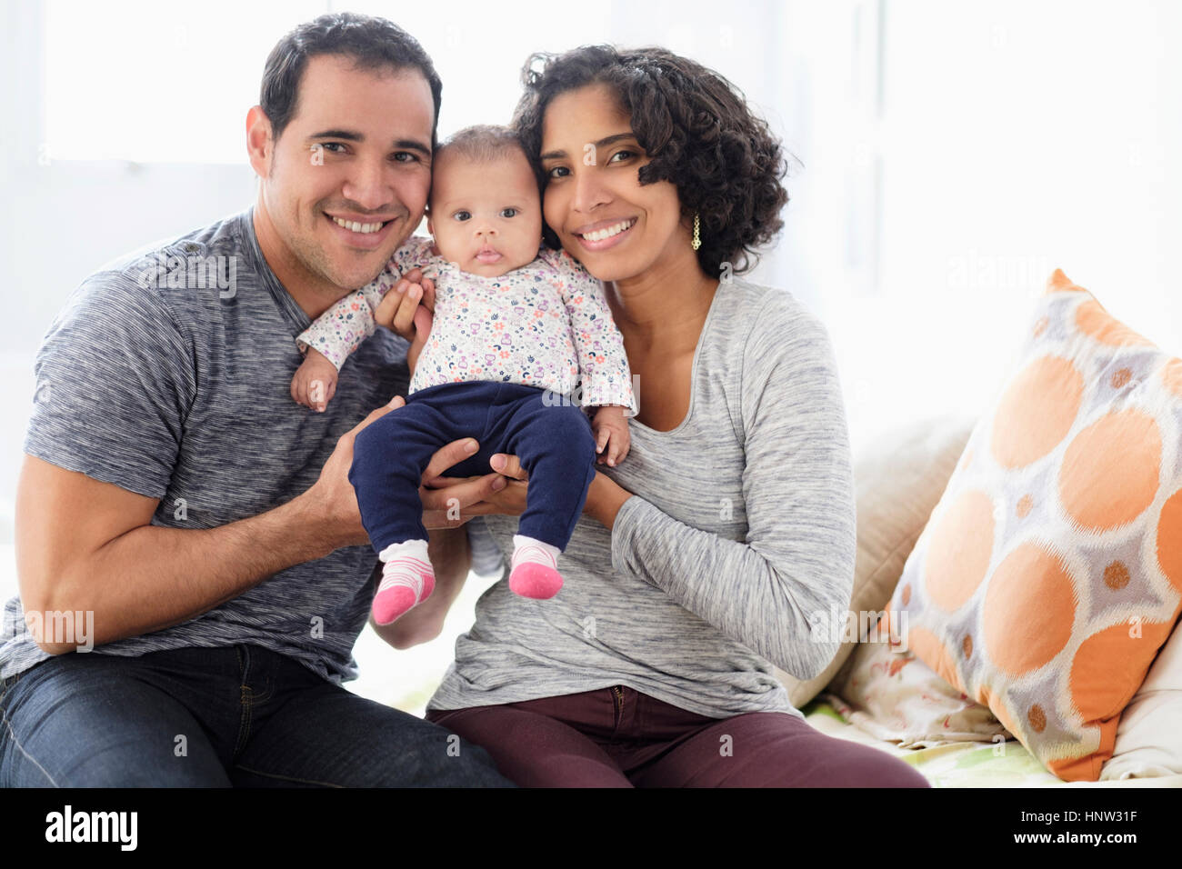 Hispanic mother and father posing with baby daughter Stock Photo