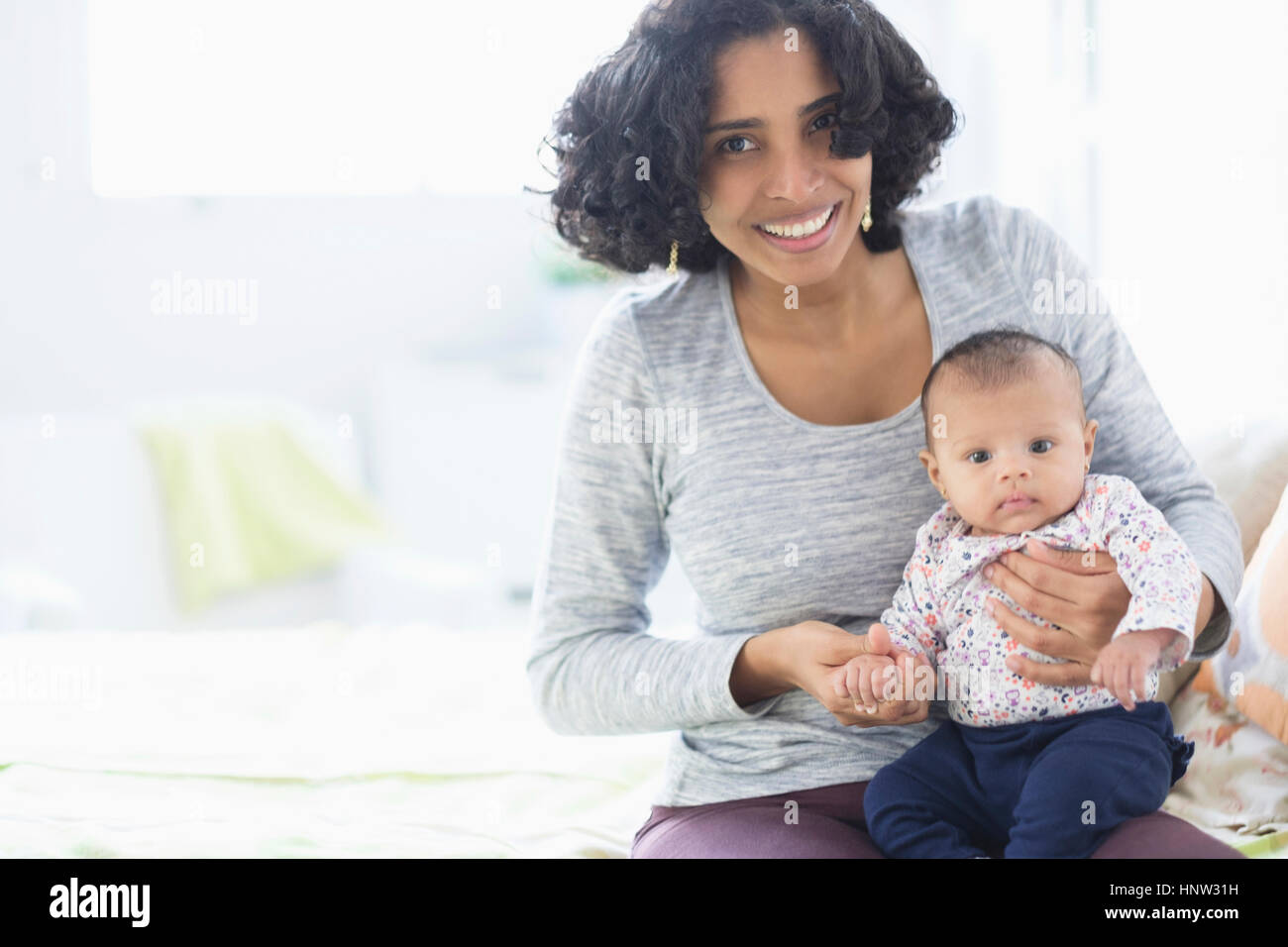 Hispanic mother posing with baby daughter Stock Photo