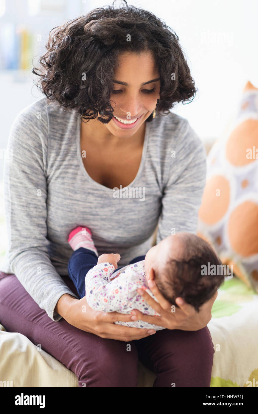 Hispanic mother cradling baby daughter Stock Photo