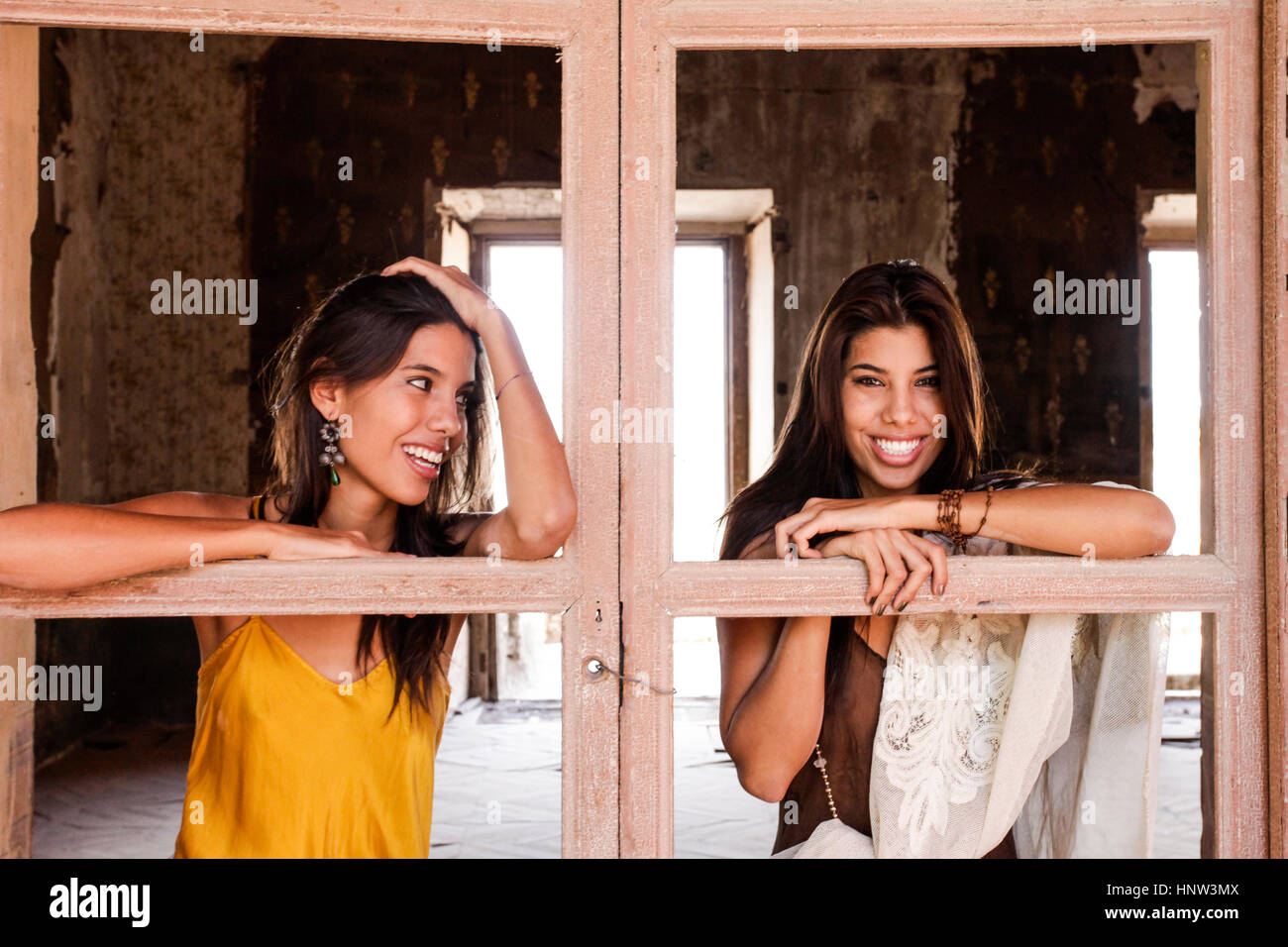 Brunette women leaning on windowless doors Stock Photo