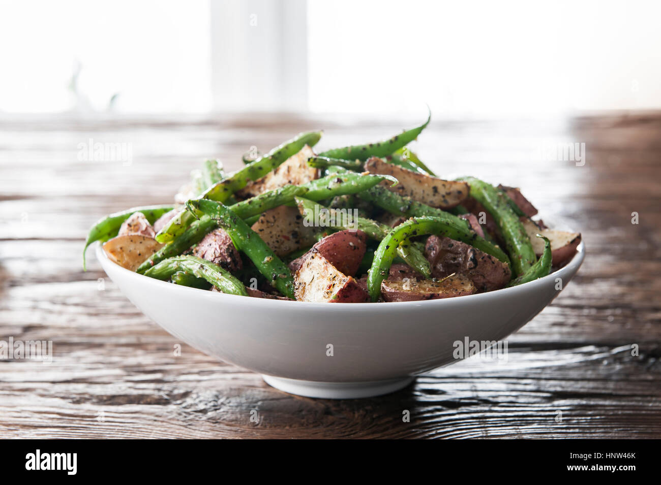 Bowl of green beans and roasted potatoes Stock Photo
