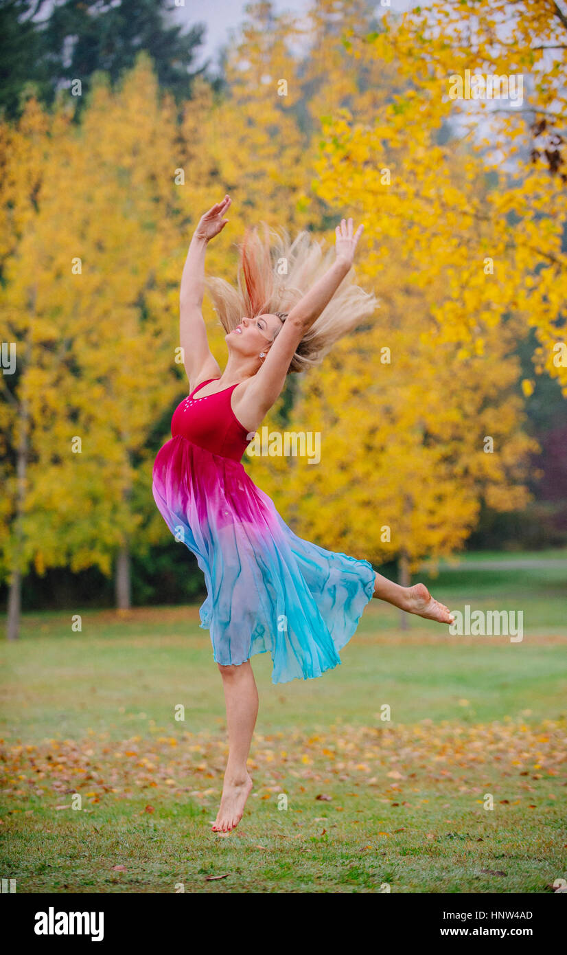 Caucasian ballerina dancing in park Stock Photo