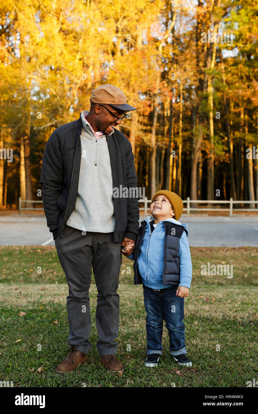 Father and son holding hands in park Stock Photo - Alamy