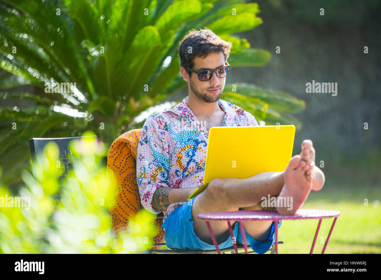 Man with feet up using laptop computer Stock Photo