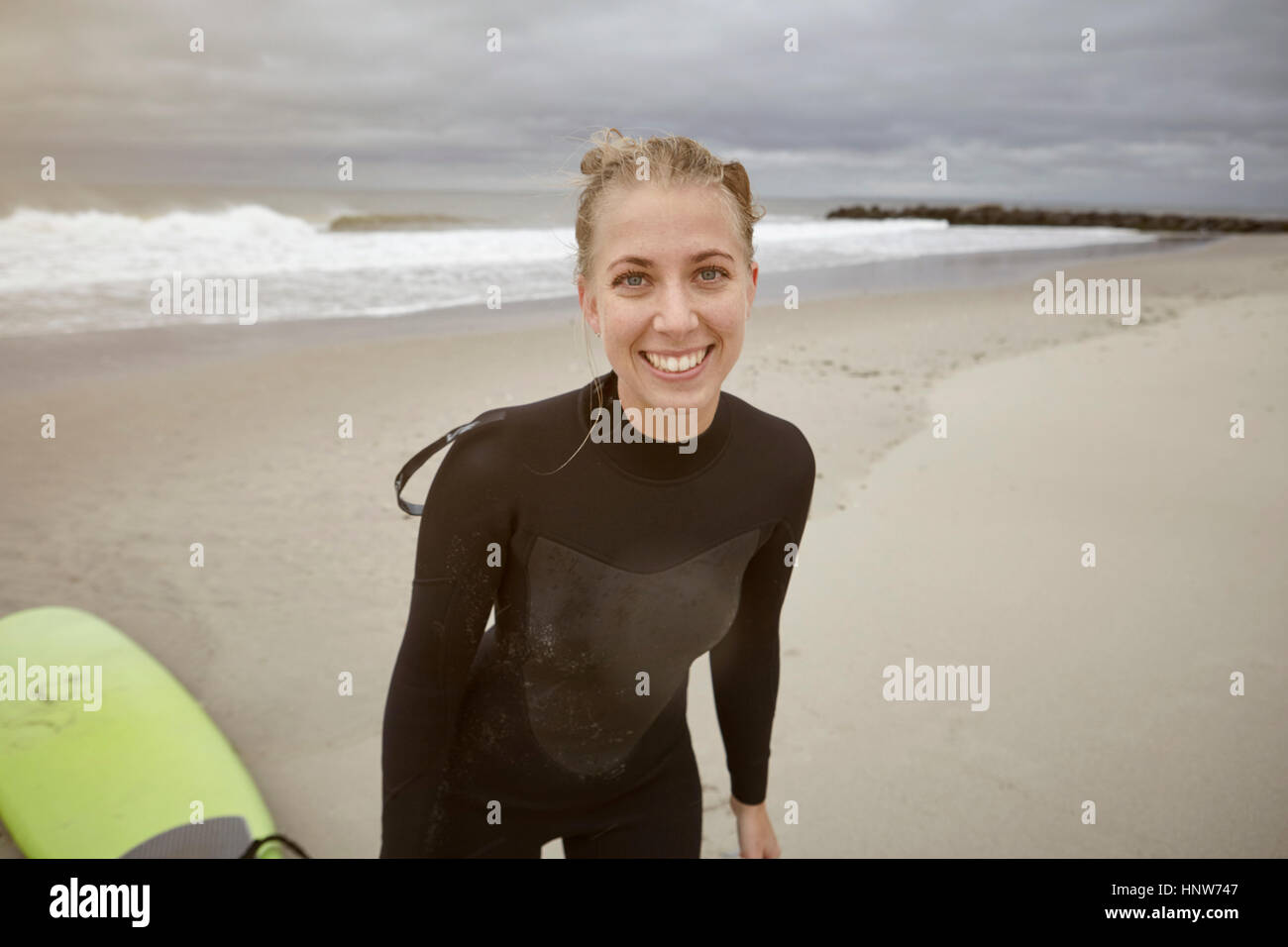 Portrait of young female surfer on Rockaway Beach, New York, USA Stock Photo
