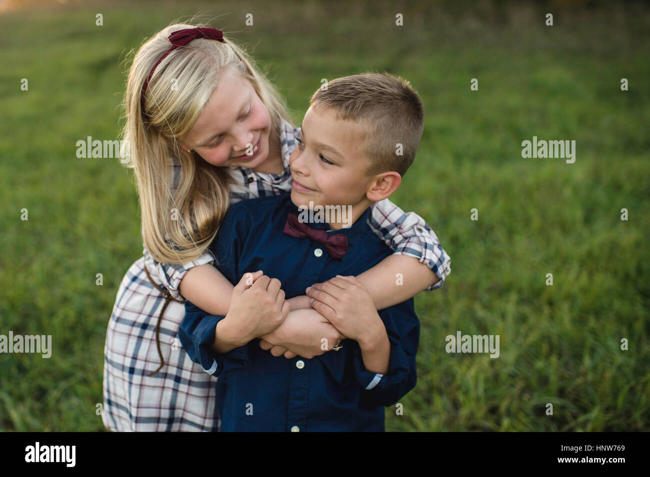 Sister hugging brother smiling Stock Photo