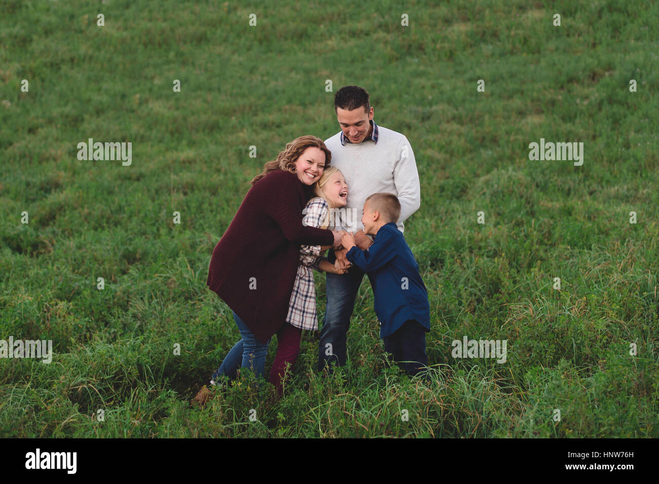 Family in field hugging Stock Photo