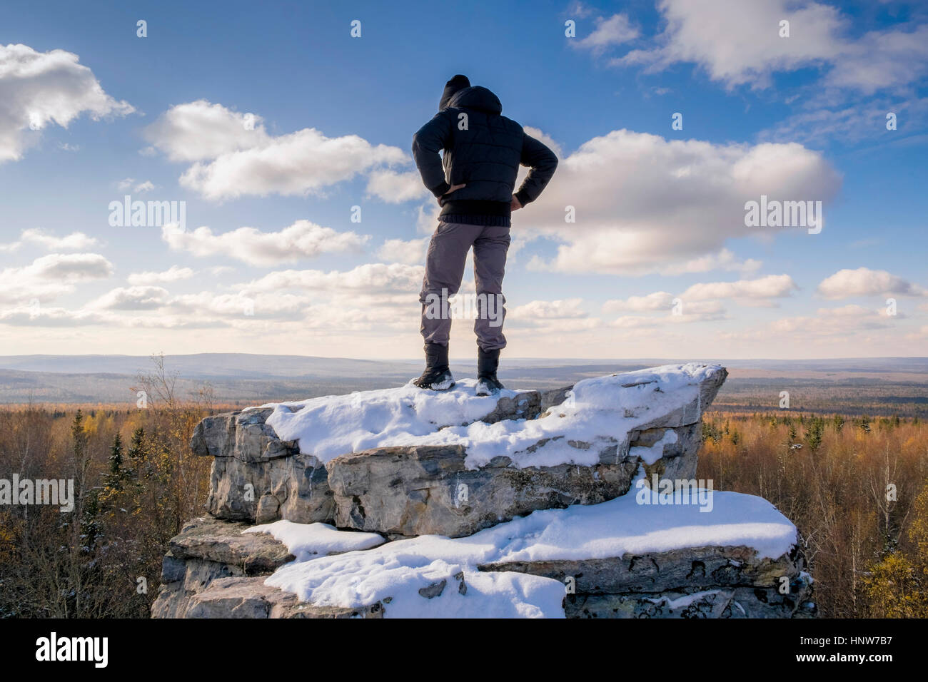 Man viewing landscape from top of rock, Ural, Russia Stock Photo