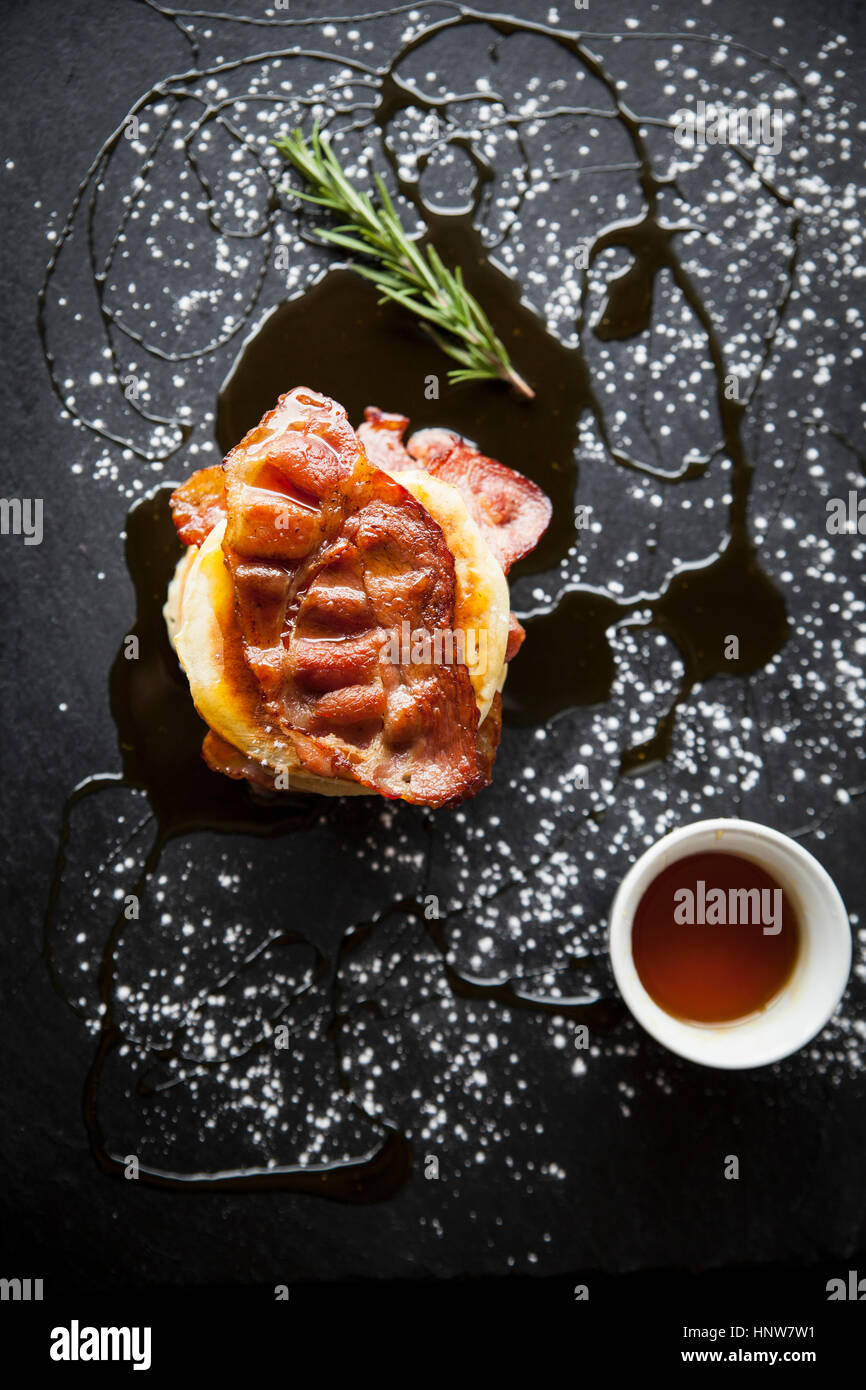 Overhead view of breakfast bacon crumpet with maple syrup on slate Stock Photo