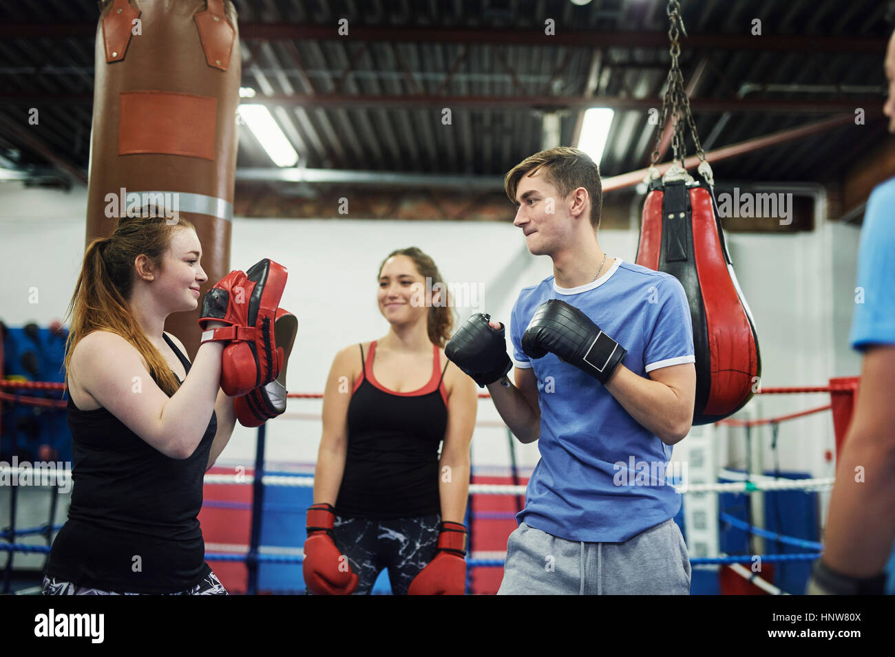 Male boxer training, poised to punch teammates punch mitt Stock Photo