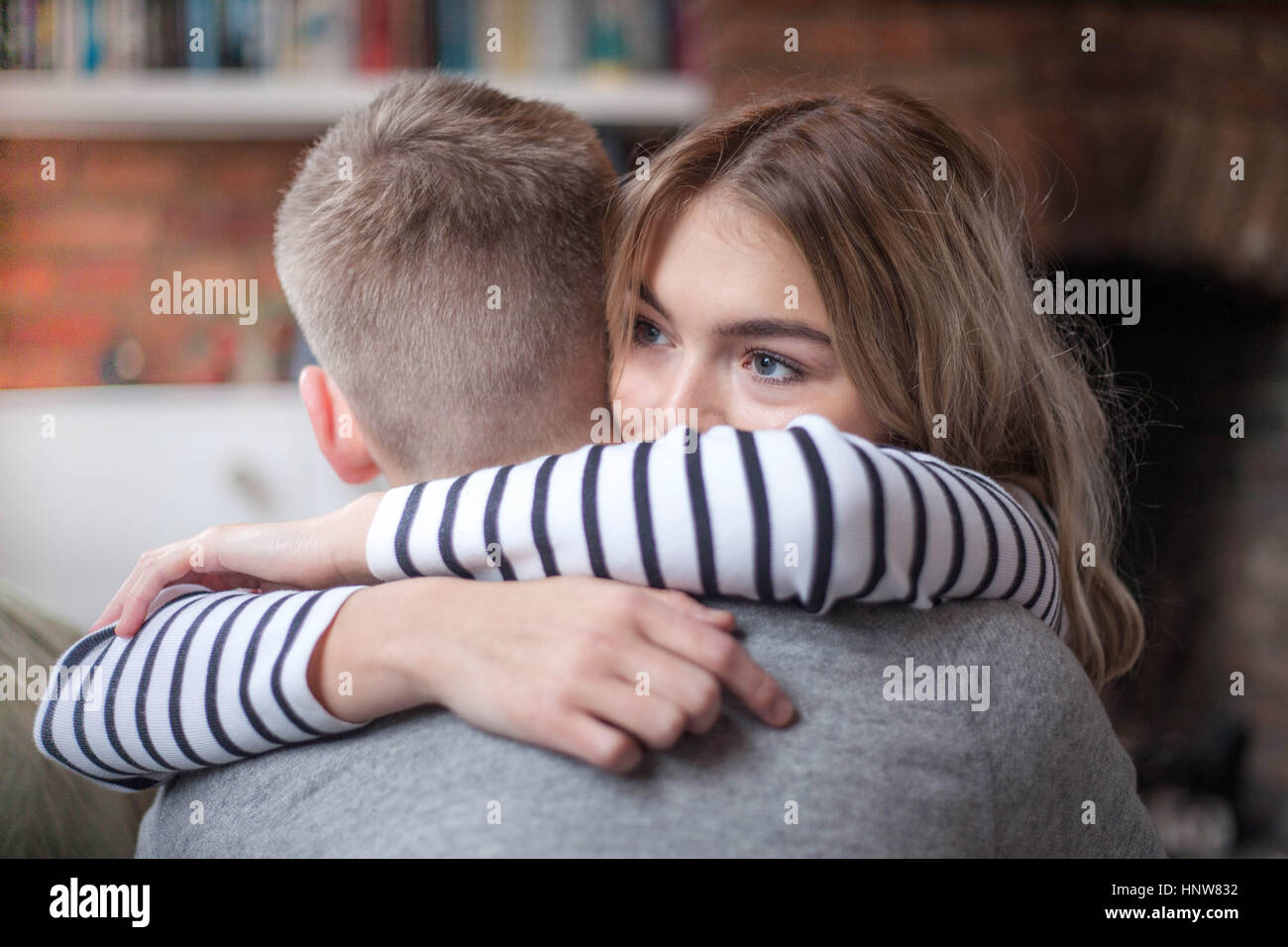 Young couple hugging, indoors, close-up Stock Photo