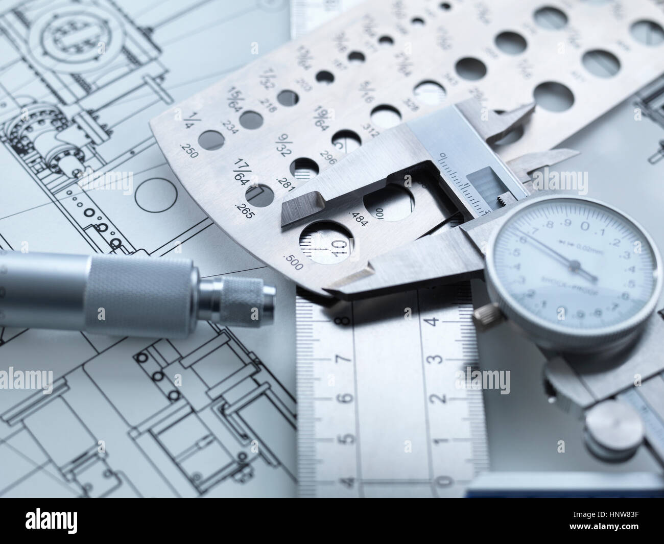 Engineering Measurement, Dial calipers sitting on a steel rule with micrometer and engineering drawings Stock Photo