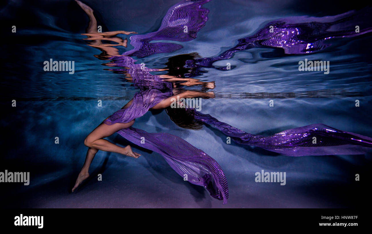 Mature woman draped in sheer fabric, underwater view Stock Photo