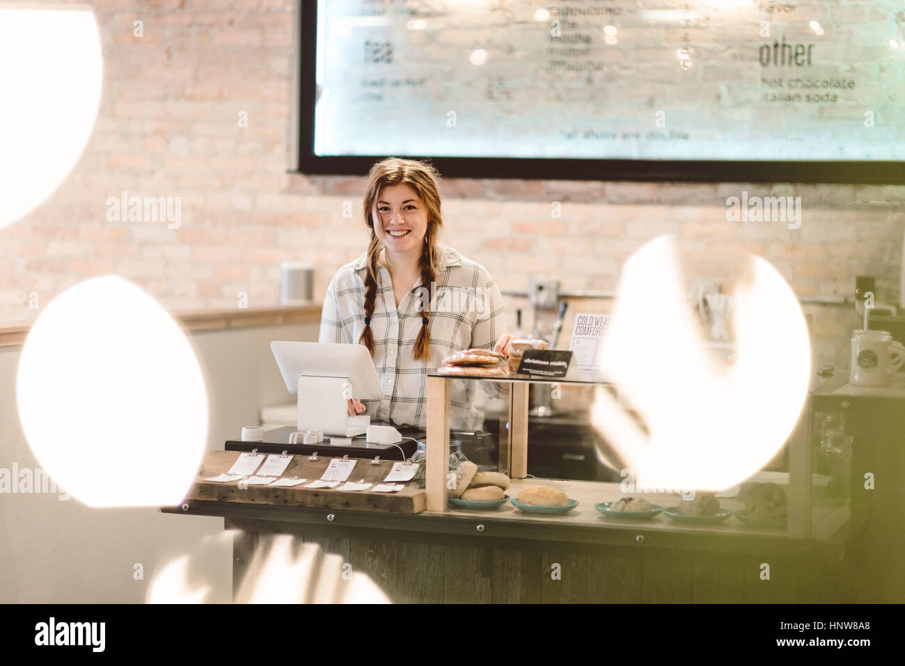 Cashier behind cash register in cafe Stock Photo
