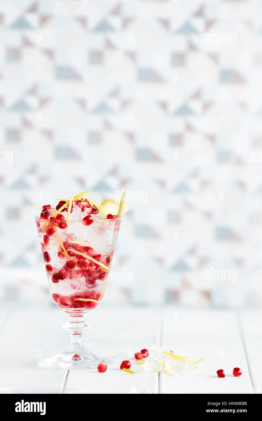 Non-alcoholic cocktail in glass with lemon rind and pomegranate Stock Photo