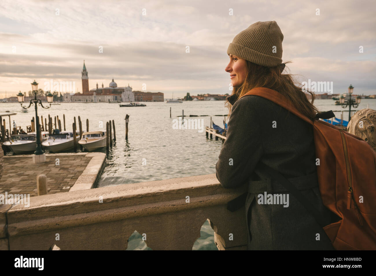 Woman on bridge in Grand Canal, San Giorgio Maggiore Island in background, Venice, Italy Stock Photo