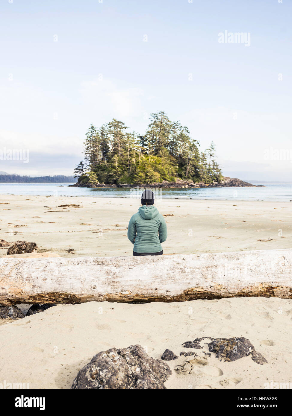 Woman looking out at island from Long Beach, Pacific Rim National Park, Vancouver Island, British Columbia, Canada Stock Photo