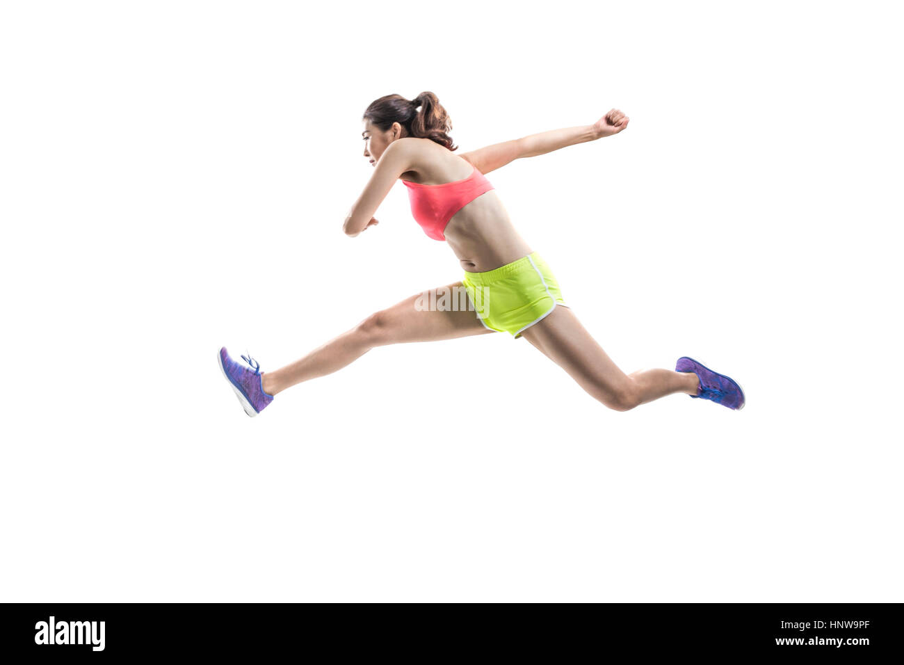 Side view of female athlete jumping Stock Photo