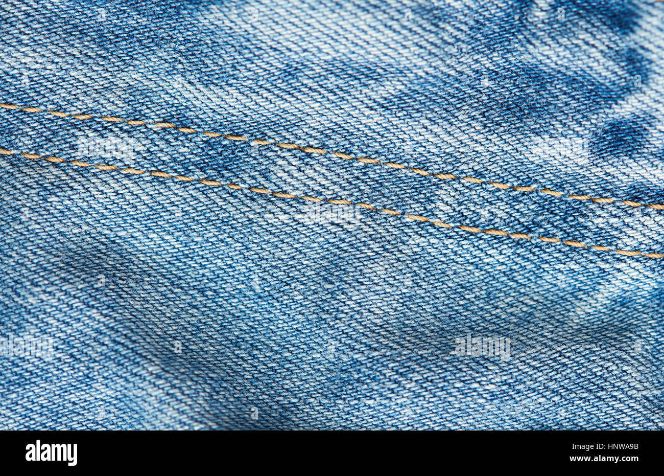 Close up of light blue jeans stitches textile fabric background Stock Photo