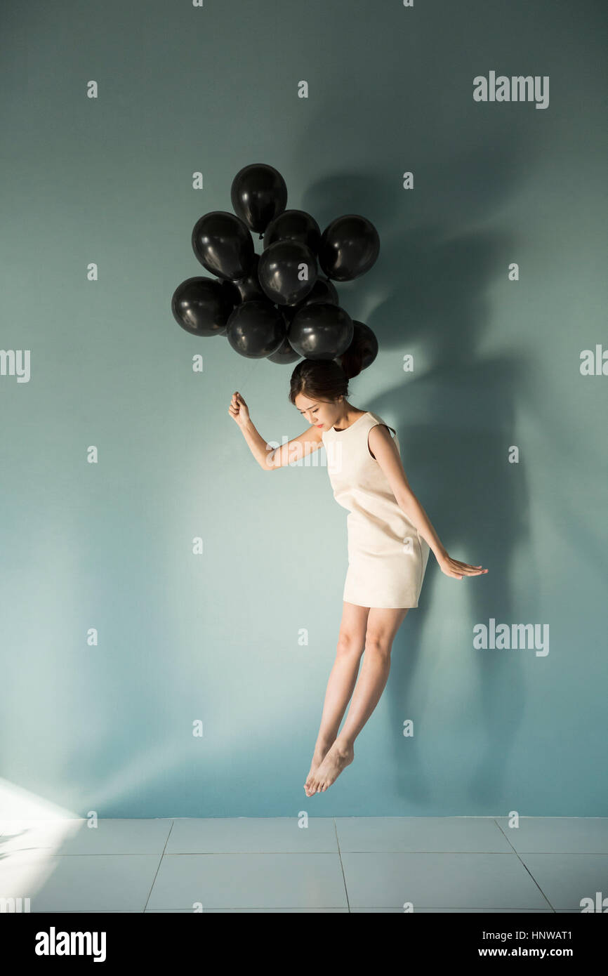 Woman with balloons floating Stock Photo