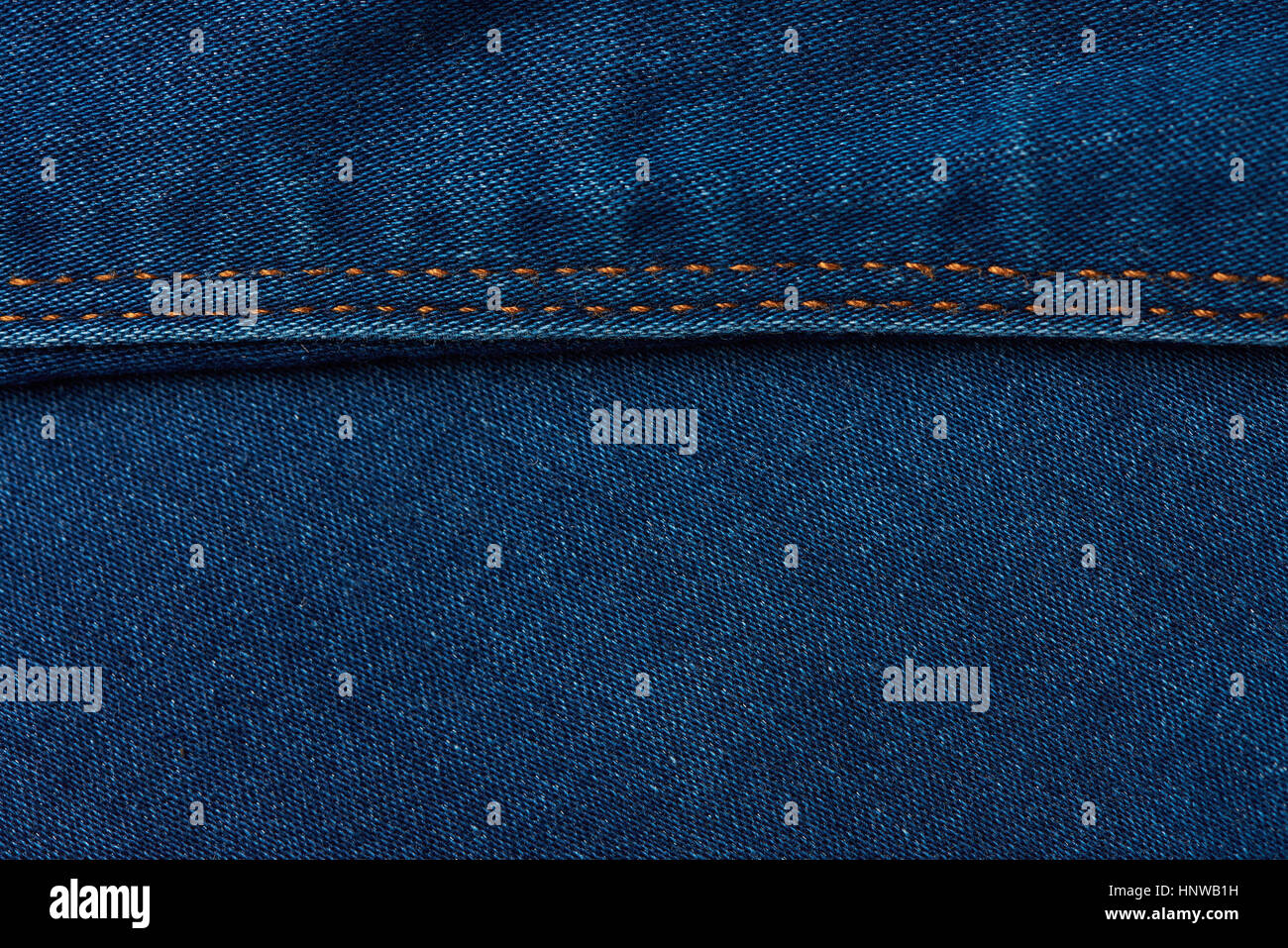 horizontal stiches on dark blue jeans background . Texture of blue jeans Stock Photo