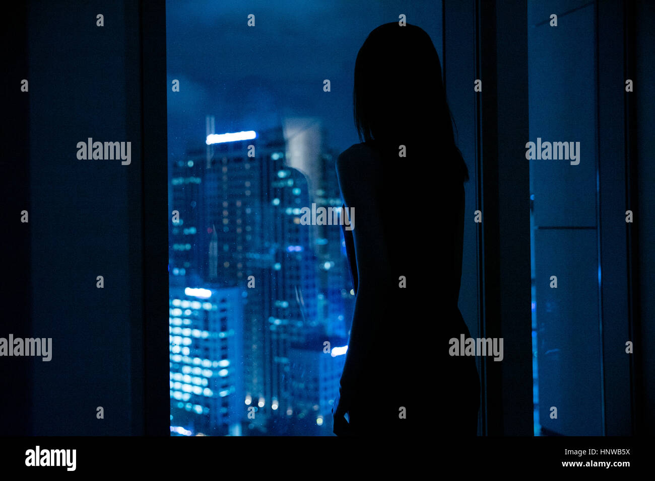 Silhouette og young woman watching night view Stock Photo