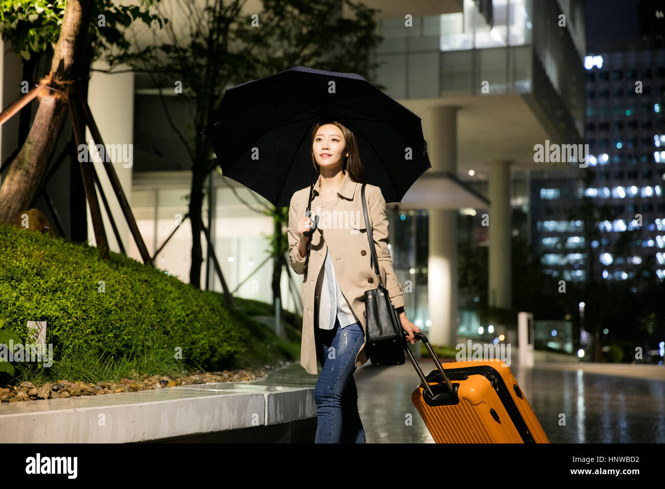 Young woman with umbrella and carrier Stock Photo