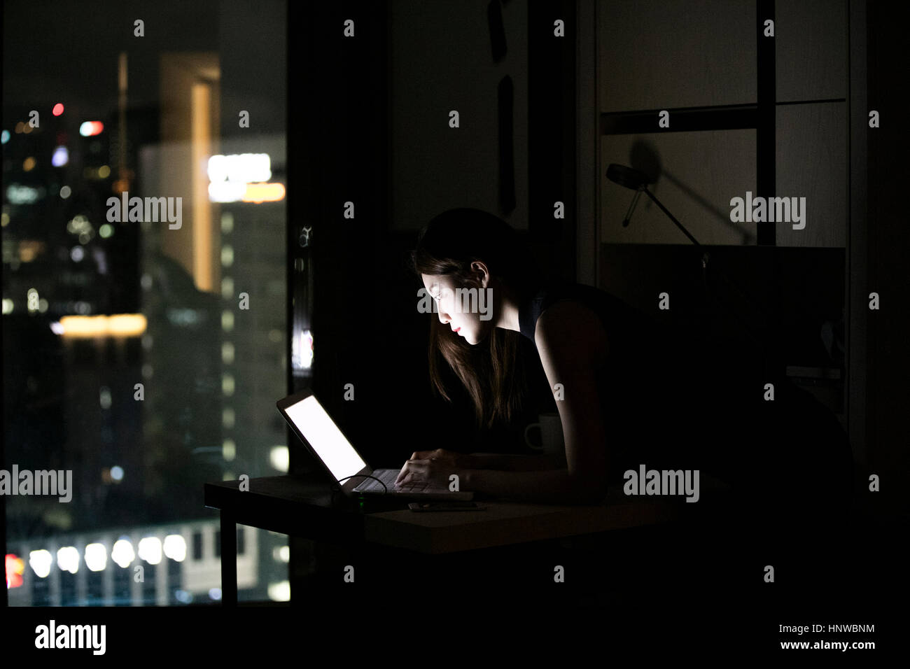 Side view of woman using notebook computer Stock Photo