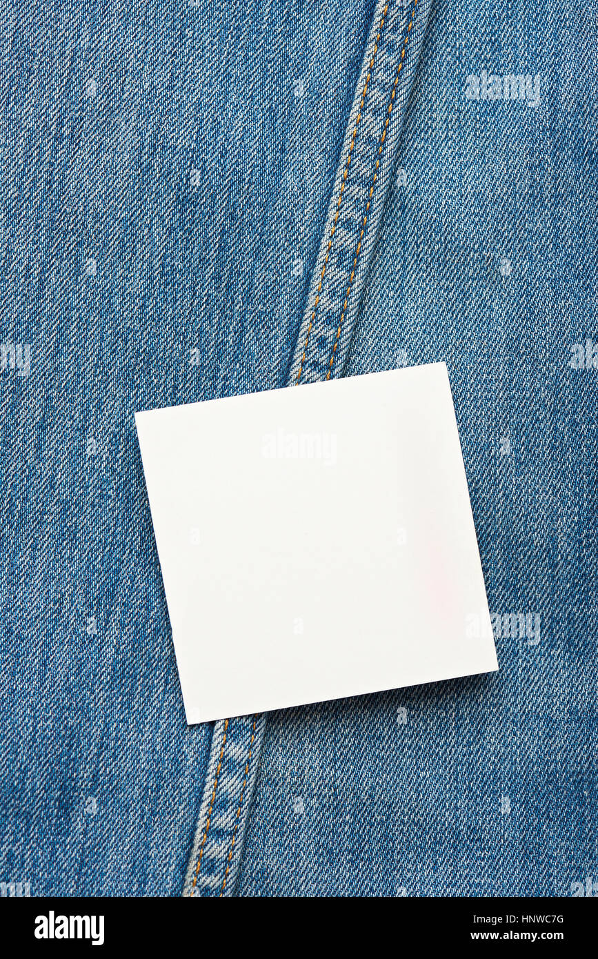 Square white label on top of blue jeans background with stitches Stock Photo