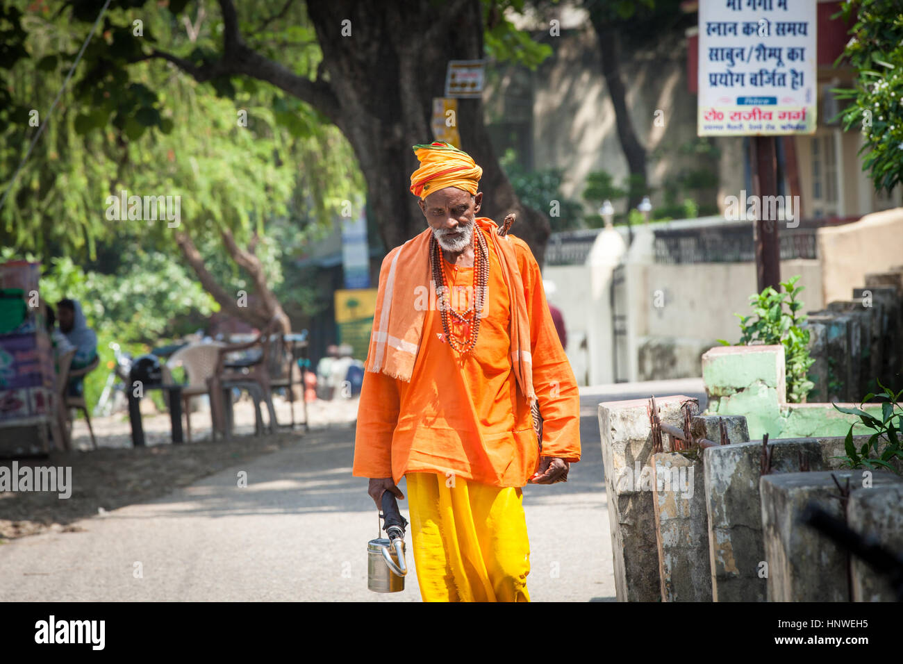 Rishikesh, India - September 24, 2014: Senior Indian Holy Man in orange robe walks down the road in Rishikesh, india on September 24, 2014. Stock Photo