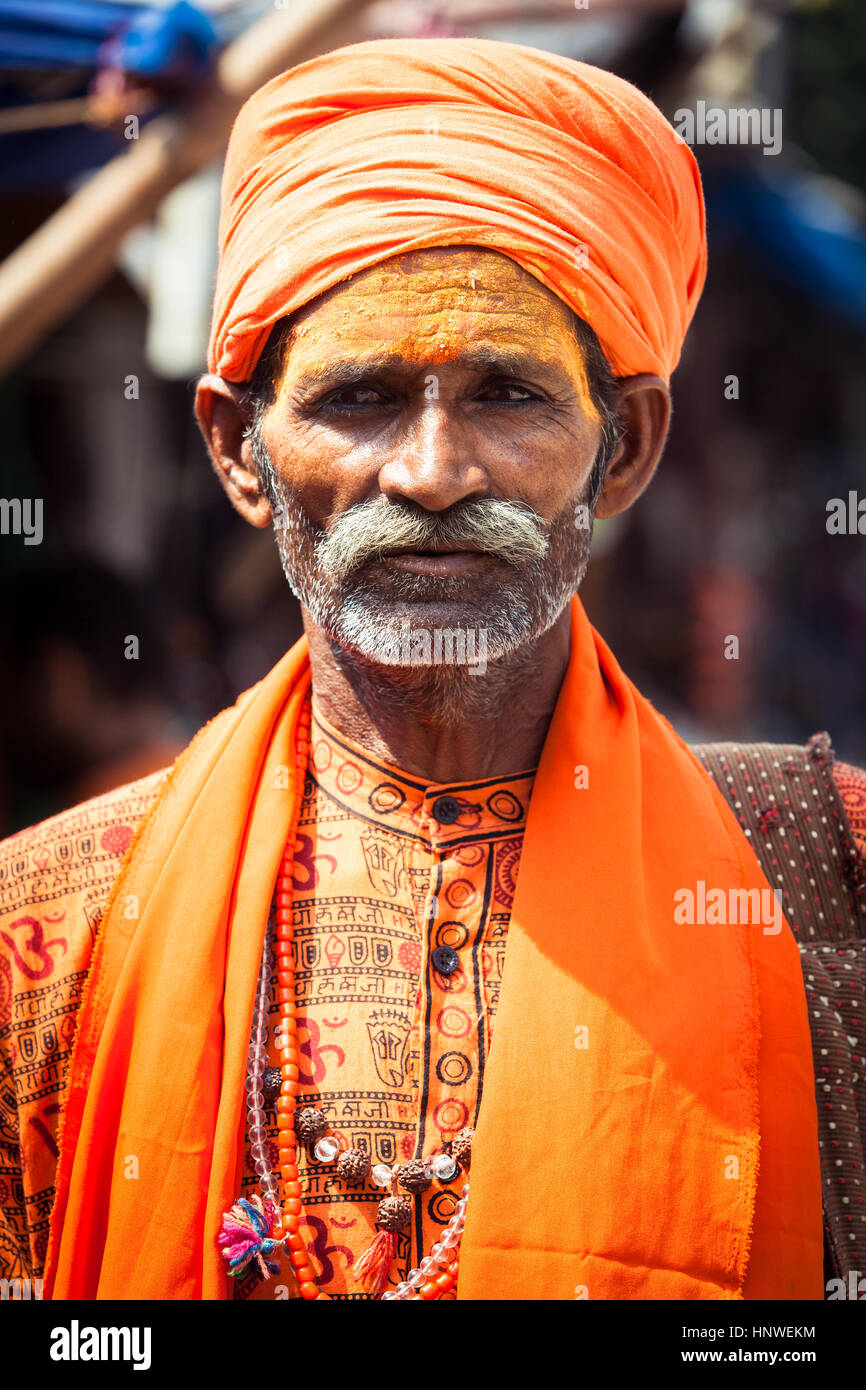 Rishikesh, India - September 22, 2014: The portrait of the indian 'Holy Man' in orange traditional clothes on the street of Rishikesh, India. Stock Photo