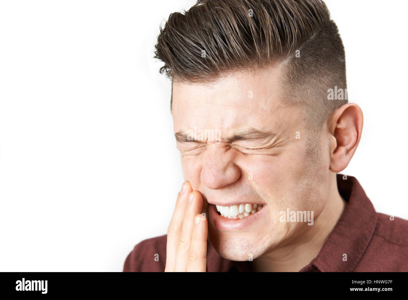 Studio Portrait Of Man Suffering With Toothache Stock Photo