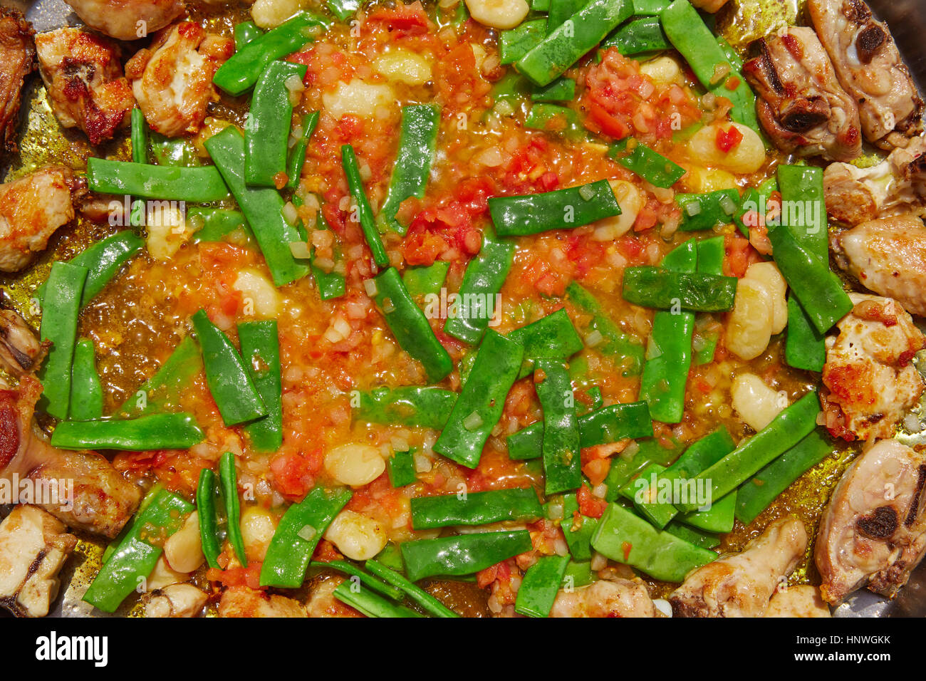 Paella from Spain recipe process ad vegetables green beans and tomato