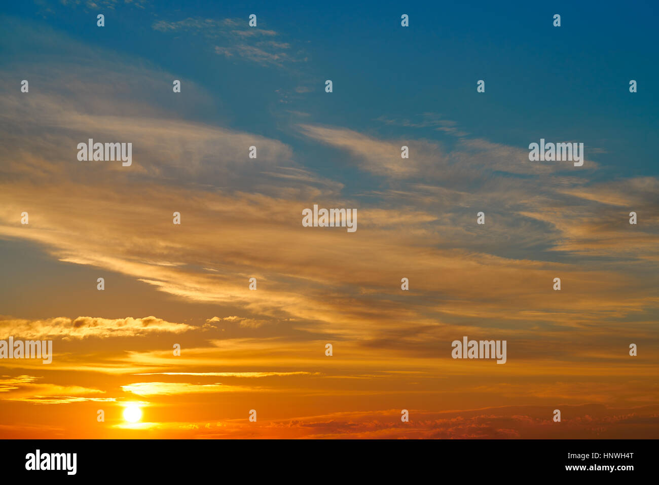Sunset sky orange clouds over blue background Stock Photo - Alamy