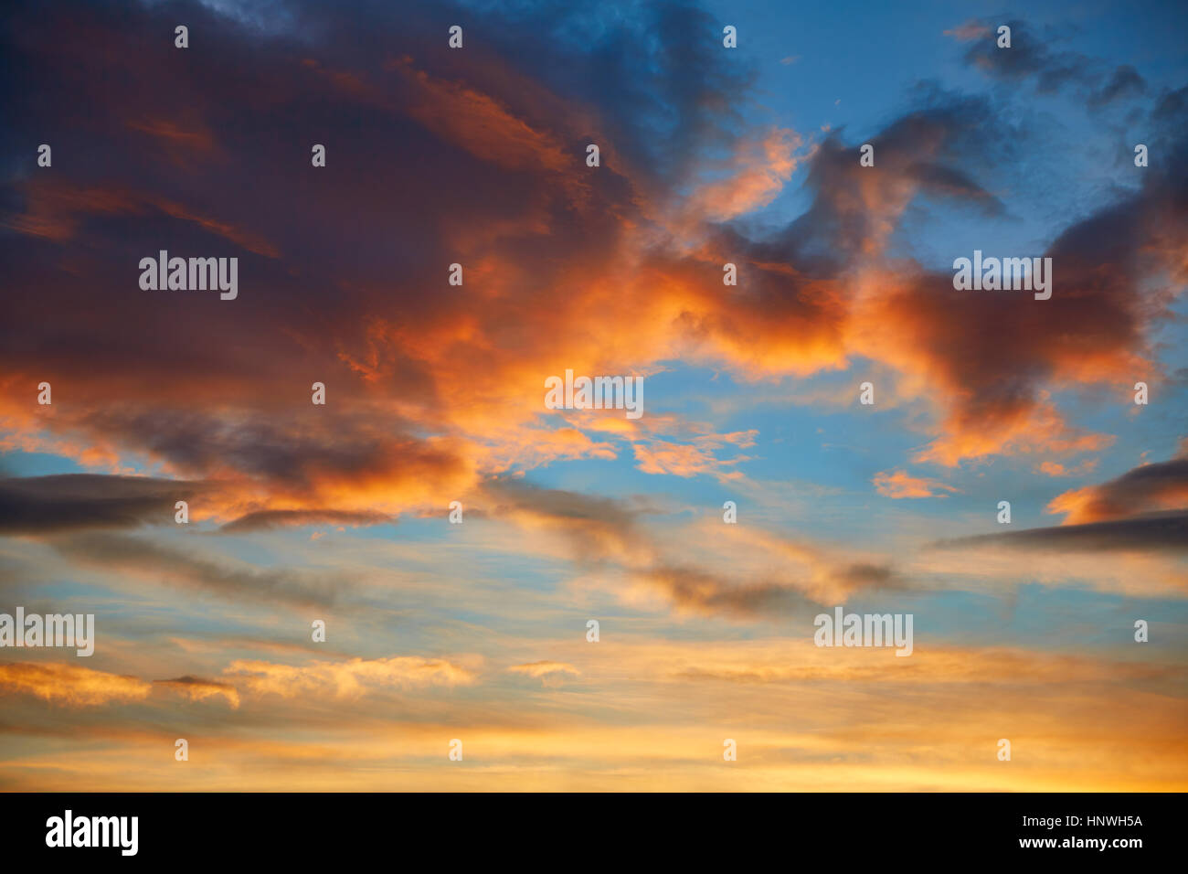 Sunset sky orange clouds over blue background Stock Photo - Alamy
