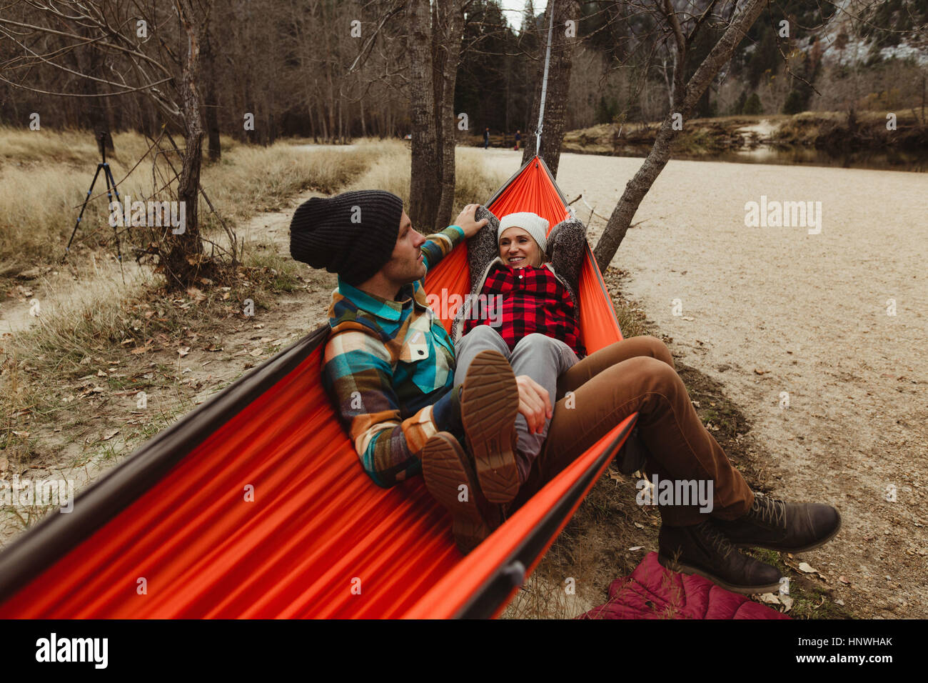 Couple reclining in red hammock at Yosemite National Park, California