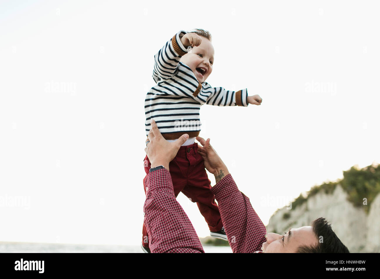 Father throwing smiling baby boy in air Stock Photo Alamy