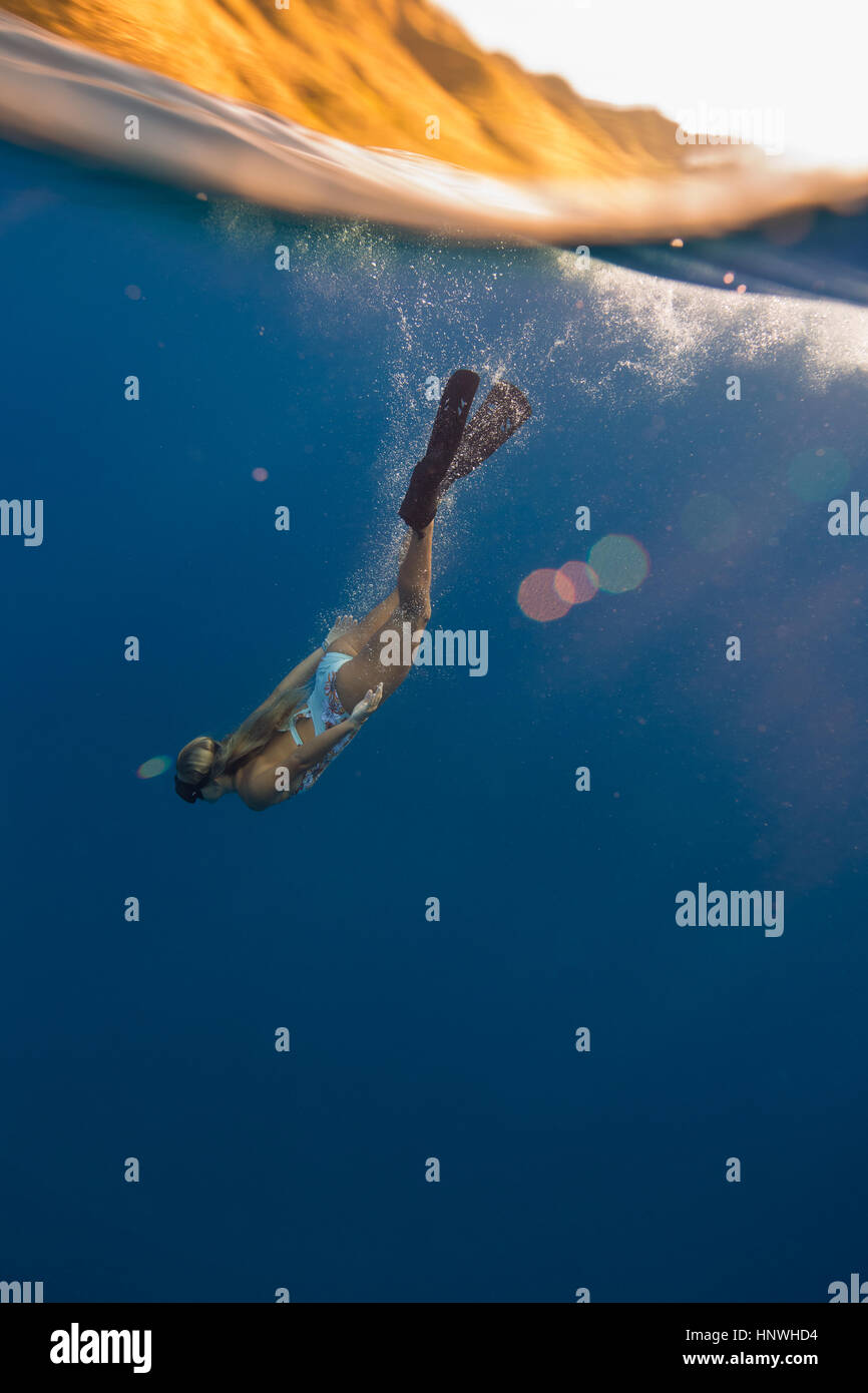 Woman wearing flippers swimming underwater, Oahu, Hawaii, USA Stock