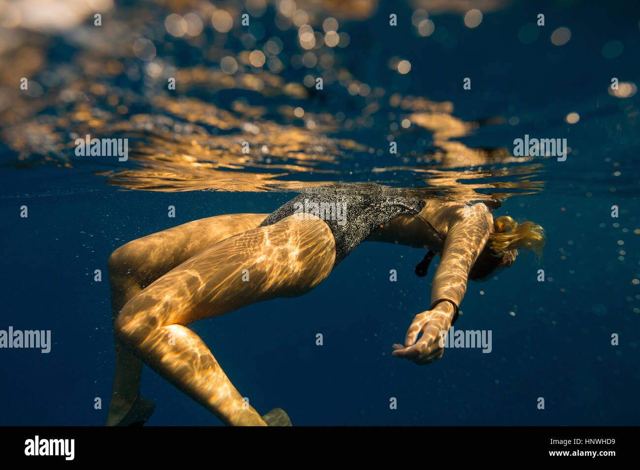 Underwater view of woman floating, Oahu, Hawaii, USA Stock Photo