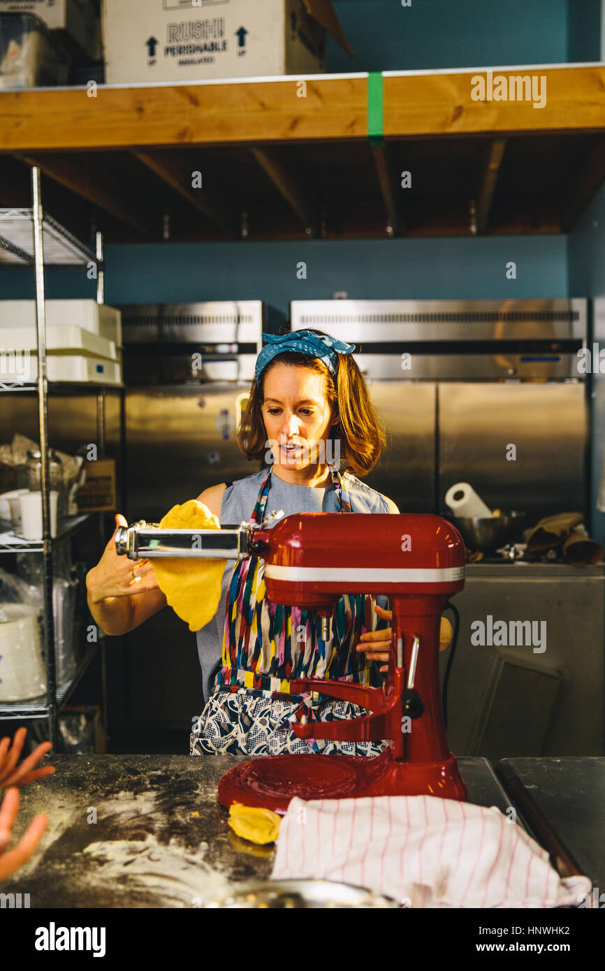 Woman flattening dough with pasta maker Stock Photo