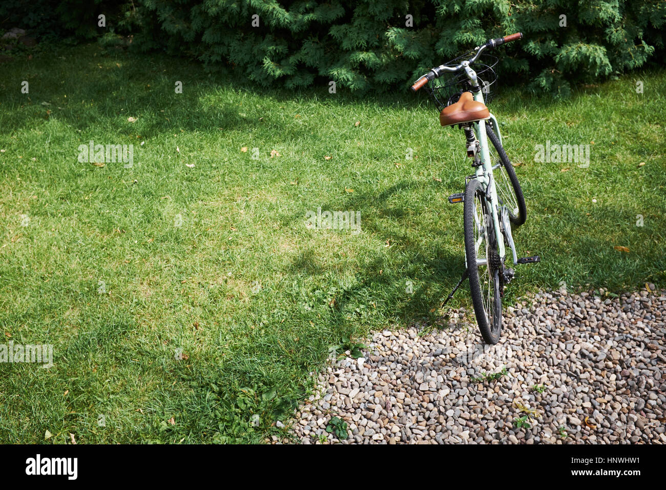 Bicycle parked on garden lawn Stock Photo