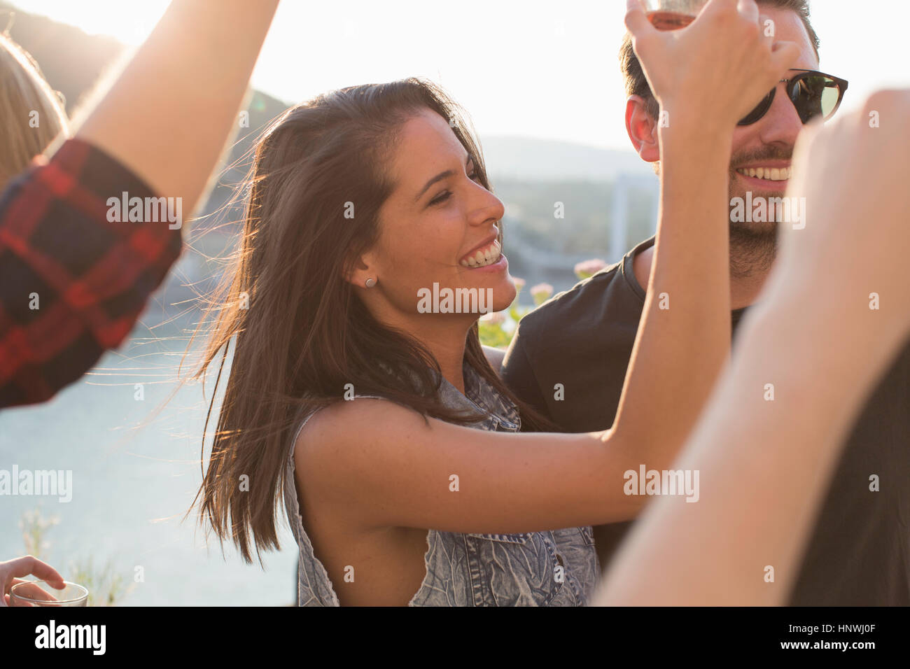 Adult friends dancing at roof terrace party on waterfront, Budapest, Hungary Stock Photo