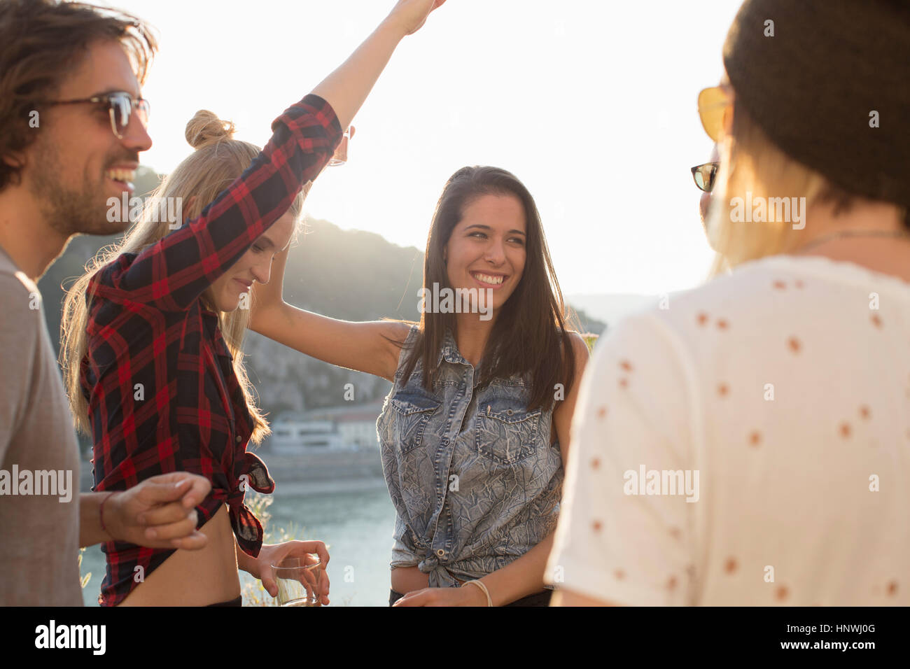 Adult friends dancing at roof terrace party on waterfront, Budapest, Hungary Stock Photo