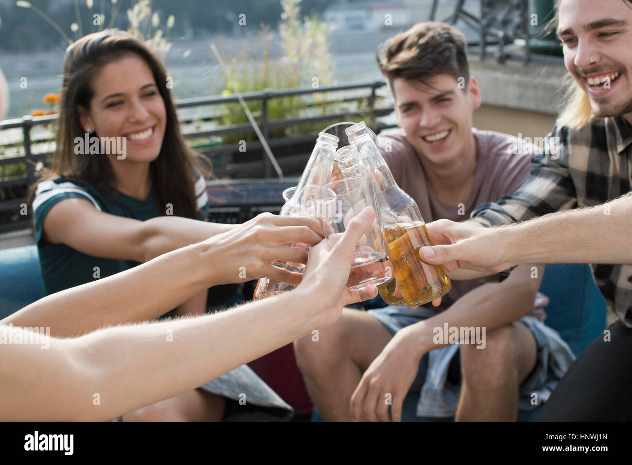 Adult friends raising a toast at roof terrace party, Budapest, Hungary Stock Photo